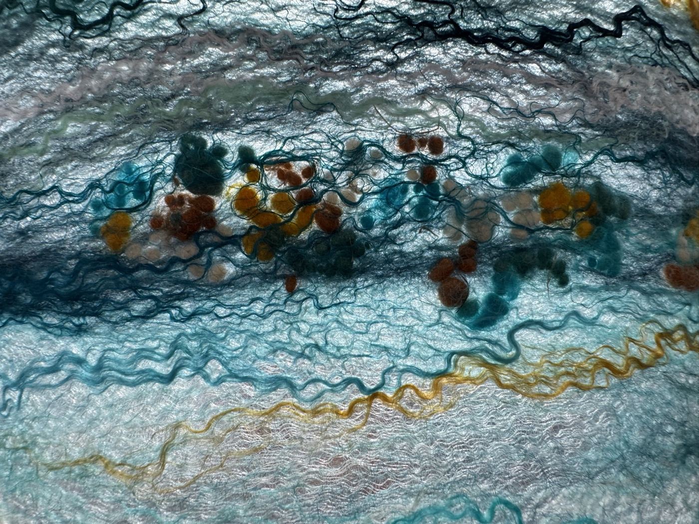 Coloured wool neps on teal felt